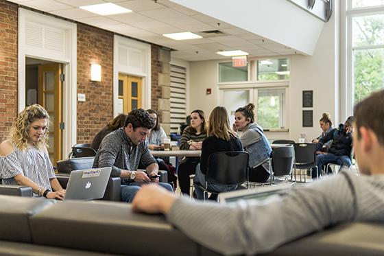 图为波胆网站的学生们在学术大楼的沙发和桌子上用笔记本电脑工作.