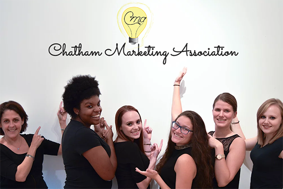 一群学生和教授的照片, holding their hands up in Vana White style to showcase the Chatham 市场营销 Association logo